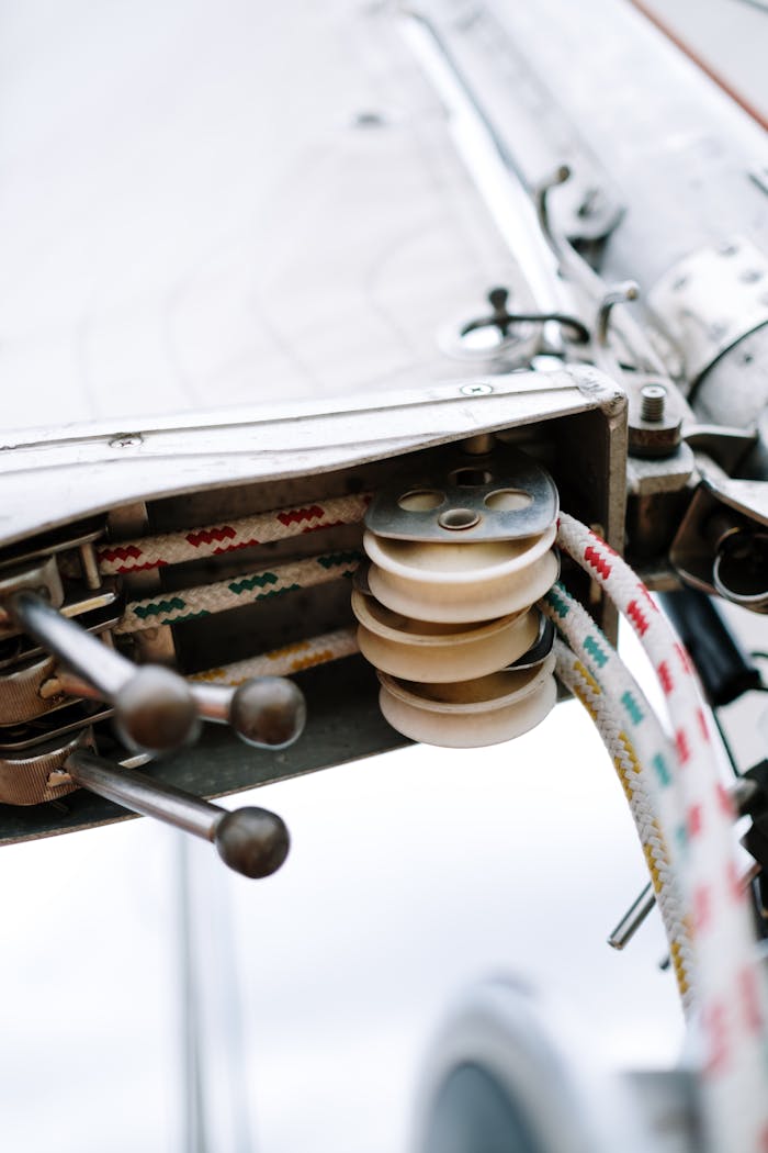 about-us-01 Detailed view of a sailboat pulley system with ropes highlighting marine mechanism.